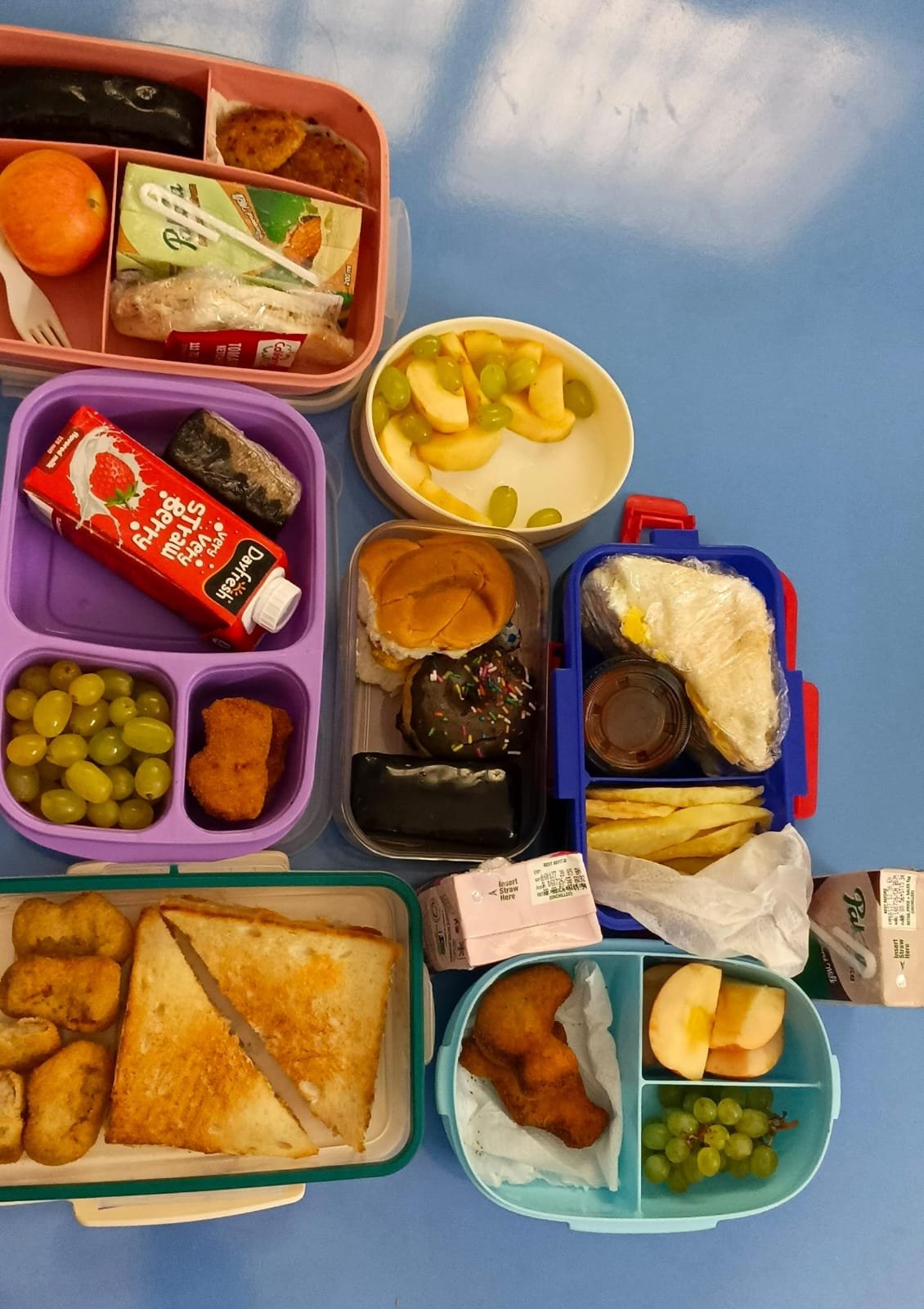 Lunchboxes laid out on a Warsis classroom table at break time