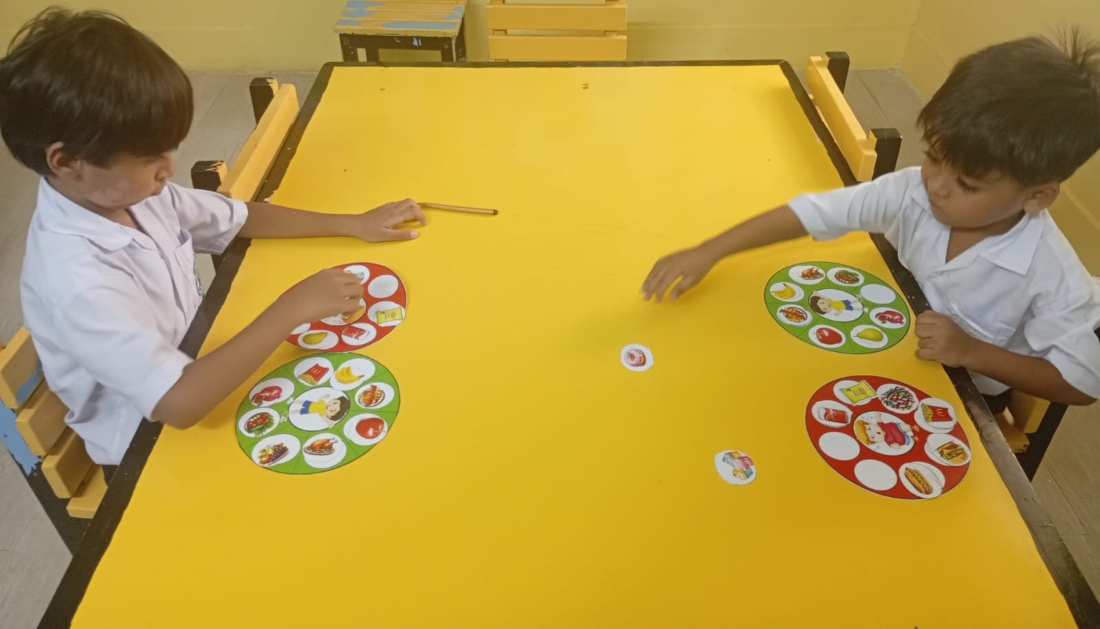 Two Warsis students playing a healthy-food matching game at a classroom table