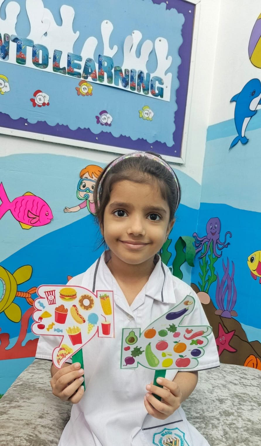 A Warsis student smiling with her completed healthy-food activity