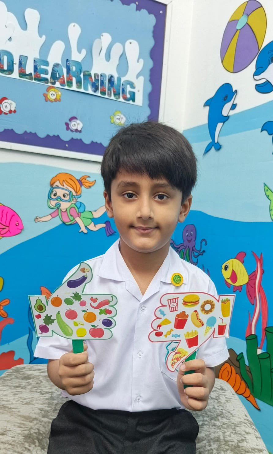 A Warsis student holding up the healthy-food paddles from his class activity