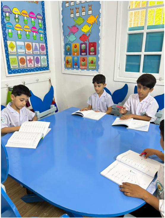 Montessori students reading together at a round classroom table at Warsis