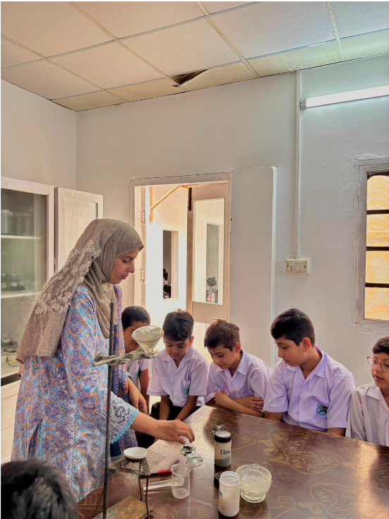 Warsis Primary students watching a science demonstration by their teacher