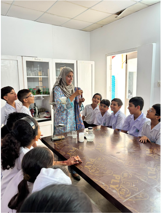 Secondary students observing a science experiment with their teacher