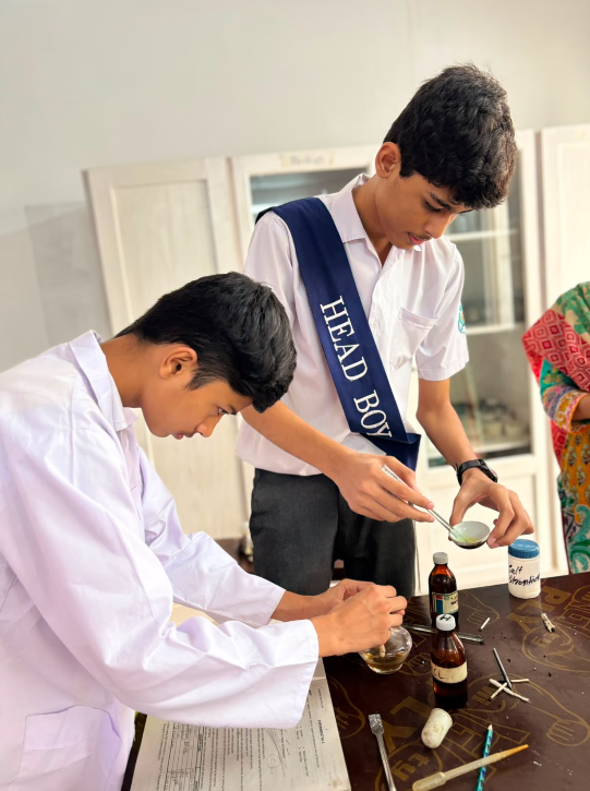 Two Warsis Secondary students completing a supervised experiment together